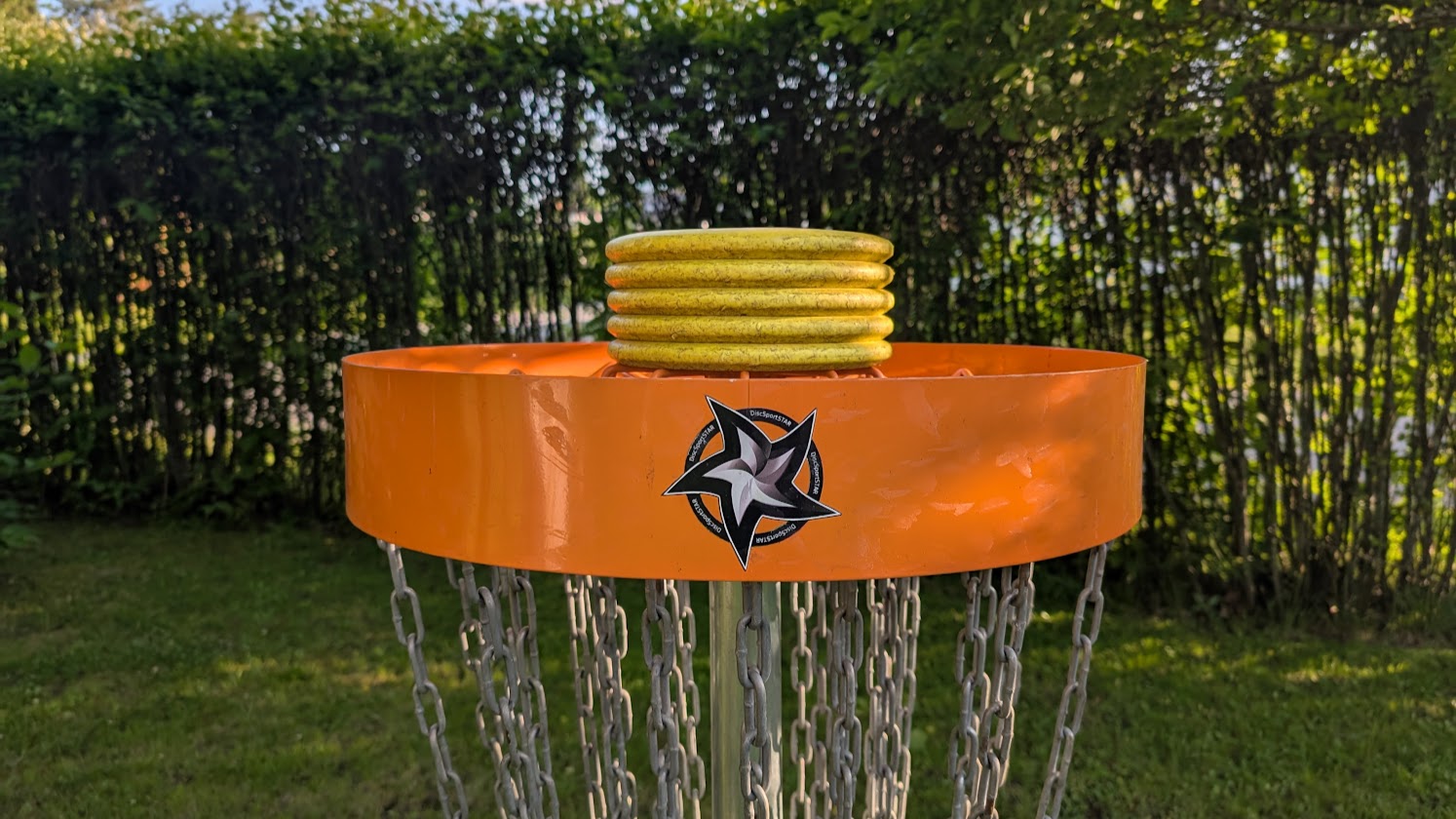 Viisi putterikiekkoa frisbeegolf-korin päällä